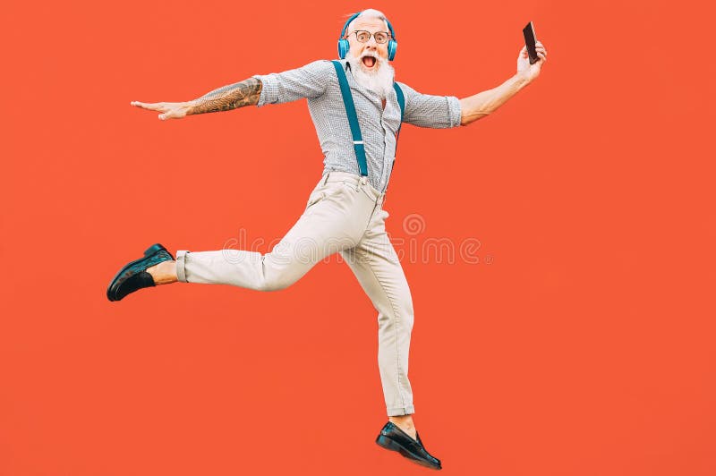 Hombre loco mayor salta mientras escucha música al aire libre - Hípster macho divirtiéndose bailando y celebrando la vida afuera