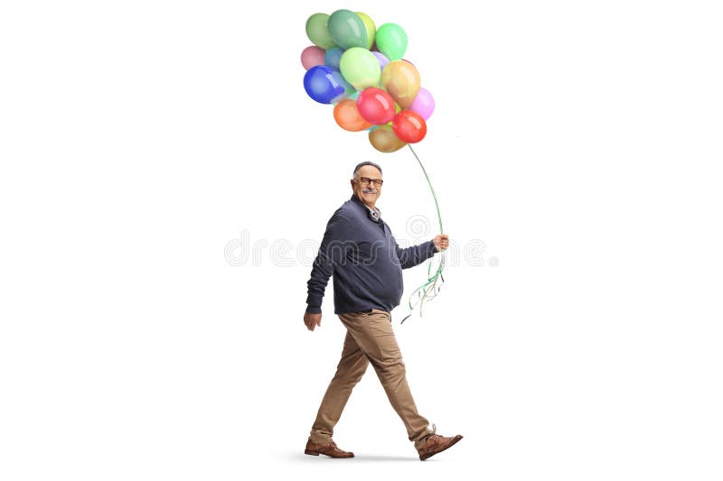 Hombre maduro caminando con un montón de globos coloridos imagen de archivo libre de regalías
