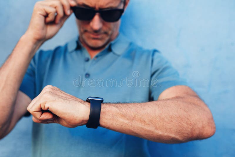 Hombre maduro que comprueba tiempo en su reloj fotografía de archivo Hombre maduro que comprueba tiempo en su reloj fotografía de archivo