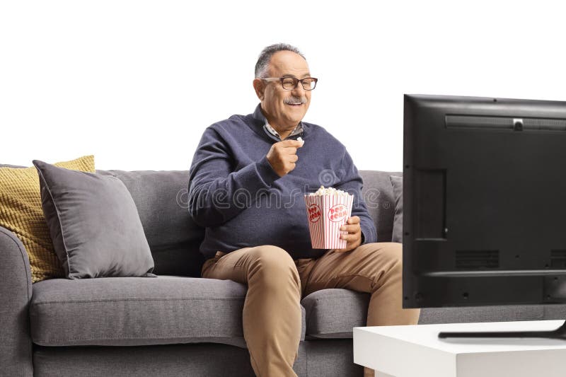 Hombre maduro viendo televisión y comiendo palomitas de maíz fotografía de archivo libre de regalías