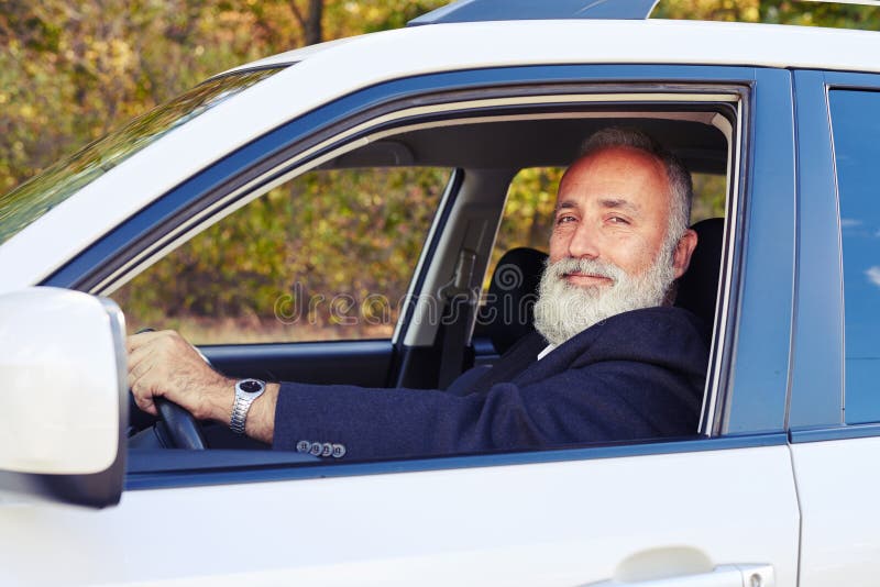 Hombre mayor barbudo hermoso en su coche fotos de archivo Hombre mayor barbudo hermoso en su coche fotos de archivo
