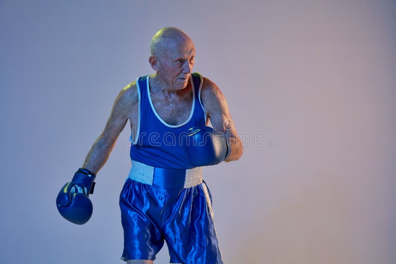 Patada. Hombre mayor vestido de ropa deportiva boxeo sobre fondo de  estudio. El modelo masculino caucásico en gran forma permanece activo y  deportivo. Concepto de deporte, actividad, movimiento, bienestar.  CopySpace, anuncio Fotografía