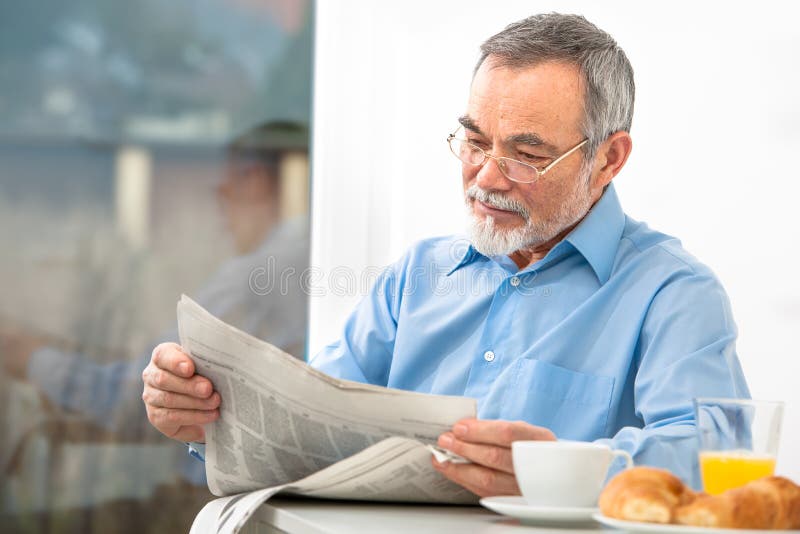 Hombre mayor con un periódico foto de archivo Hombre mayor con un periódico foto de archivo