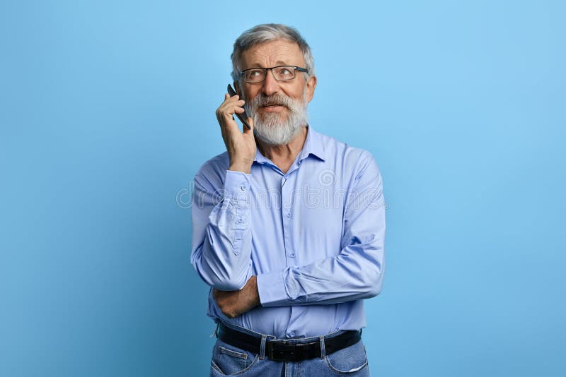 Hombre mayor hermoso que mira para arriba, hablando en el teléfono móvil fotografía de archivo libre de regalías Hombre mayor hermoso que mira para arriba, hablando en el teléfono móvil fotografía de archivo libre de regalías