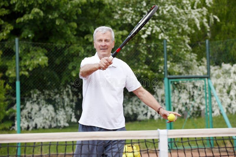 Hombre mayor que juega a tenis fotografía de archivo libre de regalías Hombre mayor que juega a tenis fotografía de archivo libre de regalías