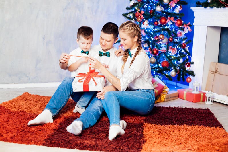 Hombre mujer e hijo pequeño sentados en el árbol de Navidad año nuevo regalos de invierno festivo fotografía de archivo