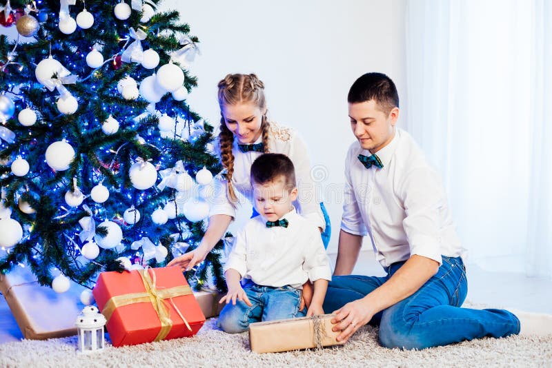 Hombre mujer e hijo pequeño sentados en el árbol de Navidad año nuevo regalos de invierno festivo fotografía de archivo libre de regalías