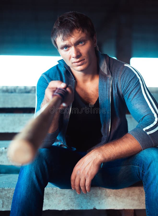Hombre muscular con el bate de béisbol imagen de archivo Hombre muscular con el bate de béisbol imagen de archivo