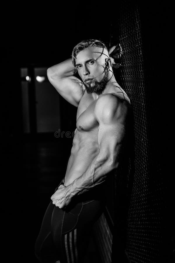 Hombre muscular joven cerca de la rejilla de la cerca Foto blanco y negro de Pekín, China imagen de archivo libre de regalías Hombre muscular joven cerca de la rejilla de la cerca Foto blanco y negro de Pekín, China imagen de archivo libre de regalías
