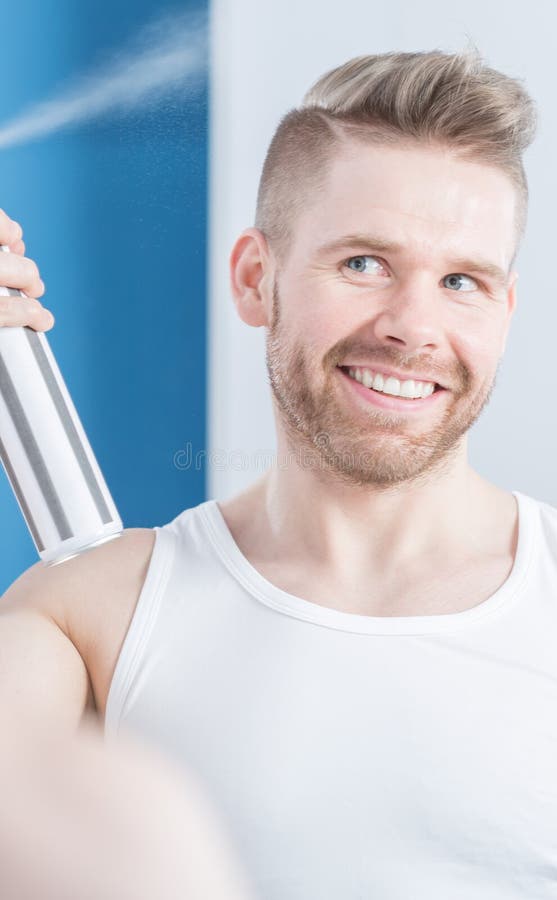 Hombre aplicando laca para el pelo imagen de archivo libre de regalías