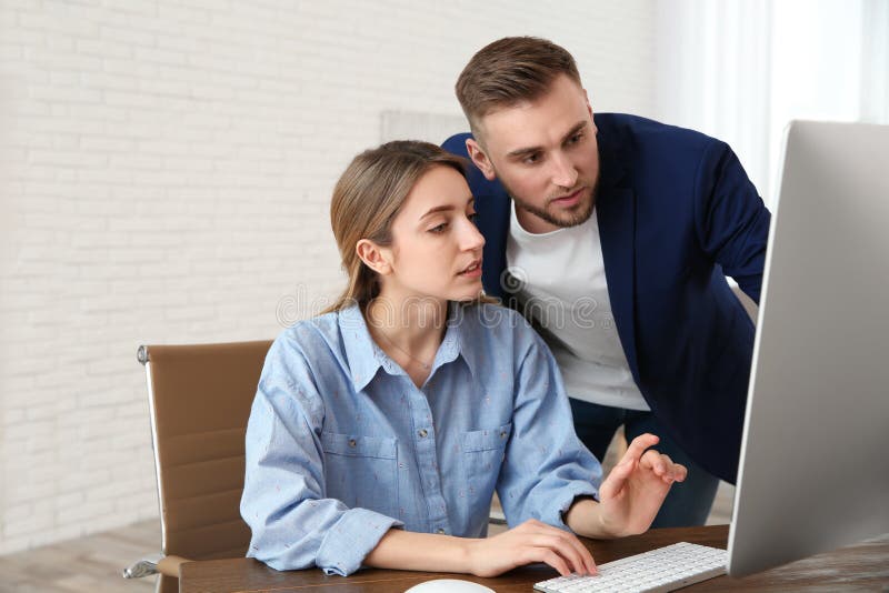 Hombre que ayuda a su trabajo del colega con el ordenador foto de archivo Hombre que ayuda a su trabajo del colega con el ordenador foto de archivo