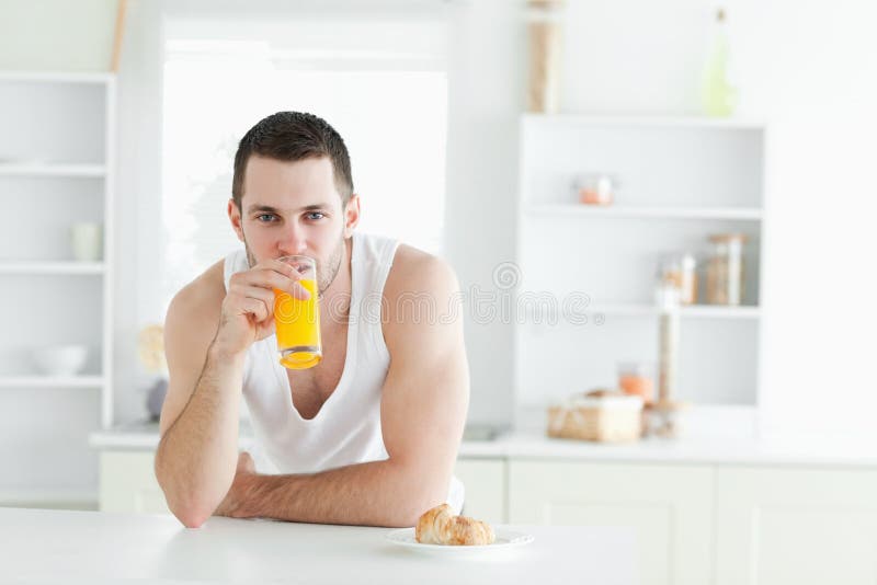 Hombre que bebe el zumo de naranja foto de archivo Hombre que bebe el zumo de naranja foto de archivo