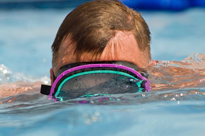 Close up image of a man swimming in a pool while wearing a scuba mask. Close up image of a man swimming in a pool while wearing a scuba mask.