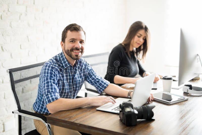 Hombre que corrige las fotos con un compañero de trabajo foto de archivo Hombre que corrige las fotos con un compañero de trabajo foto de archivo