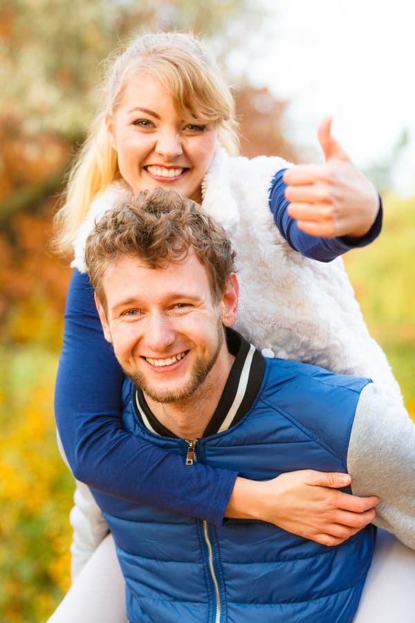 Hombre que da a cuestas paseo a la mujer en parque imagen de archivo libre de regalías Hombre que da a cuestas paseo a la mujer en parque imagen de archivo libre de regalías