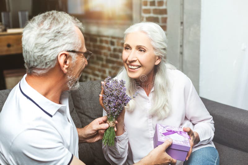 Hombre que da el ramo de lavanda a su mujer imagen de archivo Hombre que da el ramo de lavanda a su mujer imagen de archivo