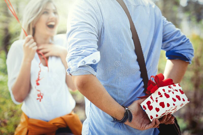 Hombre que da el regalo de la sorpresa como presente a su novia preciosa fotos de archivo libres de regalías Hombre que da el regalo de la sorpresa como presente a su novia preciosa fotos de archivo libres de regalías