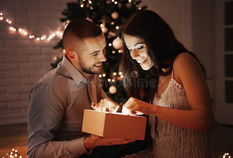 Hombre que da un regalo de Navidad a su novia imagen de archivo libre de regalías Hombre que da un regalo de Navidad a su novia imagen de archivo libre de regalías