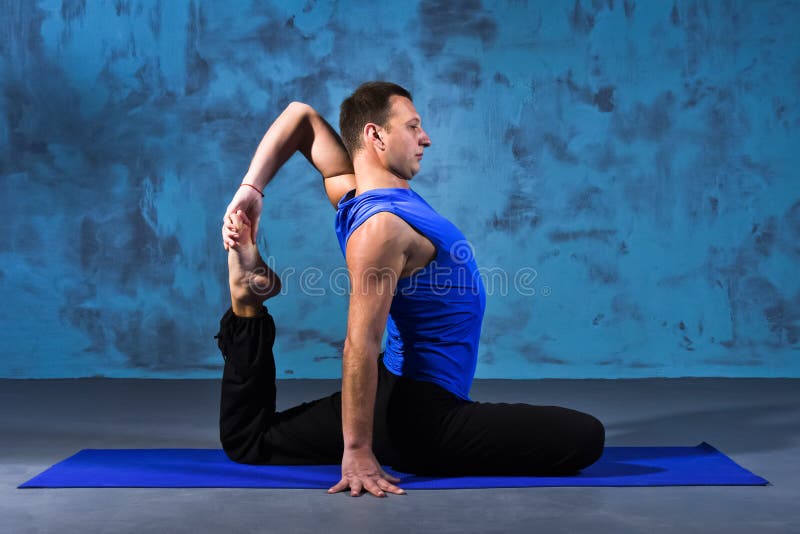 Hombre que hace Eka Pada Rajakapotasana fotografía de archivo Hombre que hace Eka Pada Rajakapotasana fotografía de archivo