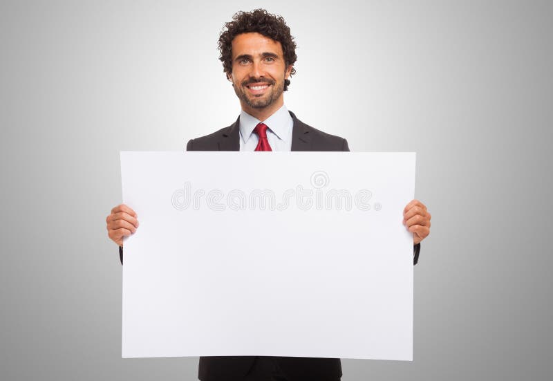 Hombre que lleva a cabo a una tarjeta en blanco fotos de archivo libres de regalías Hombre que lleva a cabo a una tarjeta en blanco fotos de archivo libres de regalías