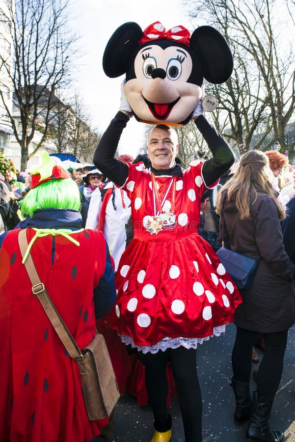 Man at street carnival in Dusseldorf lifting up the head of Minnie Mouse costume for looking out. Man at street carnival in Dusseldorf lifting up the head of Minnie Mouse costume for looking out.
