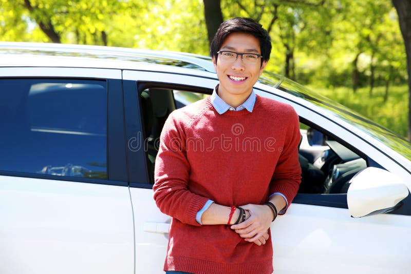 Hombre que se coloca cerca de su coche en parque imagen de archivo Hombre que se coloca cerca de su coche en parque imagen de archivo