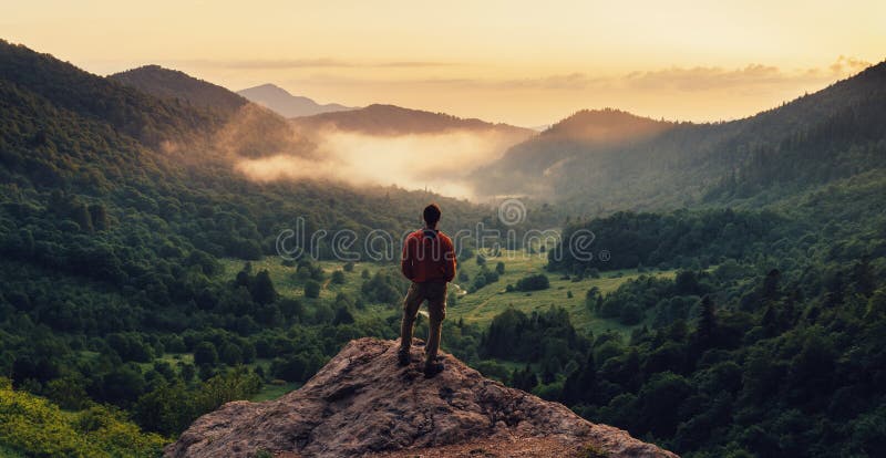 Hombre que se coloca encima del acantilado en la puesta del sol