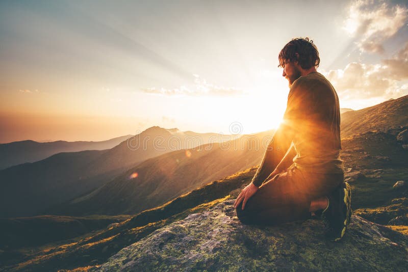 Hombre que se relaja en la forma de vida del viaje de las montañas de la puesta del sol
