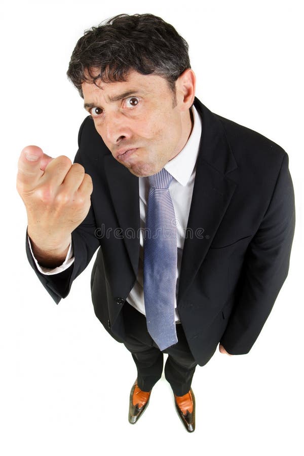 Humorous high angle portrait of a man in a business suit pointing a finger in accusation and blame with a stern uncompromising expression isolated on white. Humorous high angle portrait of a man in a business suit pointing a finger in accusation and blame with a stern uncompromising expression isolated on white