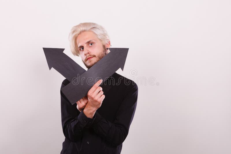 Hombre que sostiene las flechas negras que se?alan a la izquierda e a la derecha foto de archivo Hombre que sostiene las flechas negras que se?alan a la izquierda e a la derecha foto de archivo