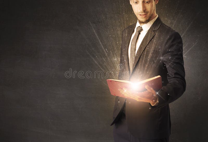 Hombre que sostiene un libro. Tenencia y lectura del hombre un libro brillante
