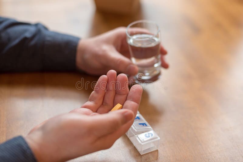 Hombre que toma las vitaminas diarias para la buena salud imagen de archivo Hombre que toma las vitaminas diarias para la buena salud imagen de archivo