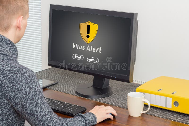 Hombre que usa el ordenador con alarma del virus de ordenador
