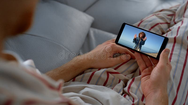 Hombre relajado haciendo llamadas por web cam en casa. chica de viaje con cuidado hablando almacen de video