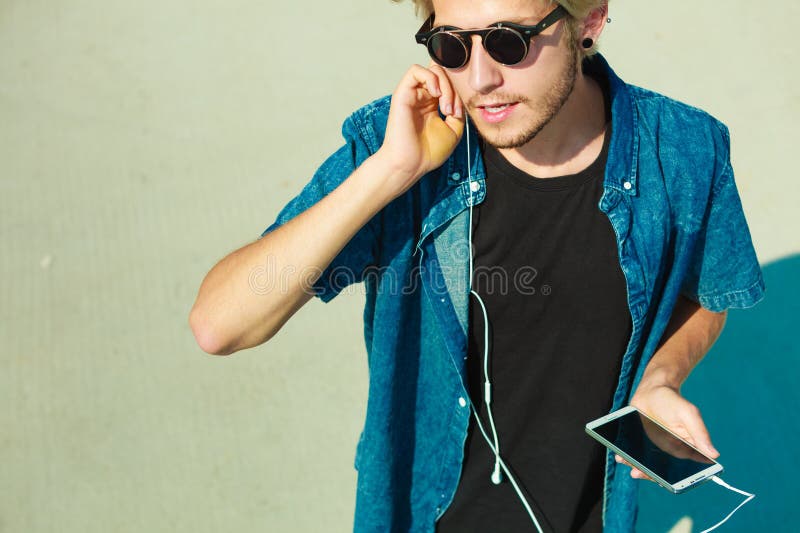 Hombre rubio en gafas de sol que escucha la música fotos de archivo Hombre rubio en gafas de sol que escucha la música fotos de archivo