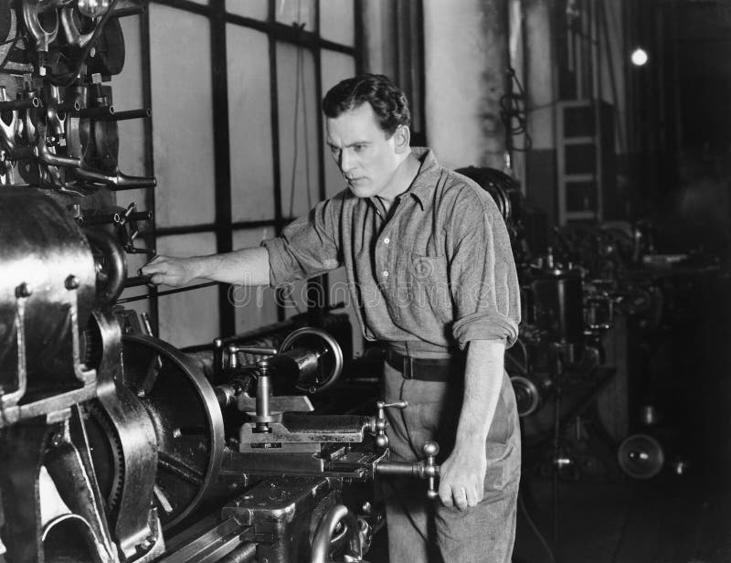 Hombre serio que usa la máquina grande imagen de archivo Hombre serio que usa la máquina grande imagen de archivo
