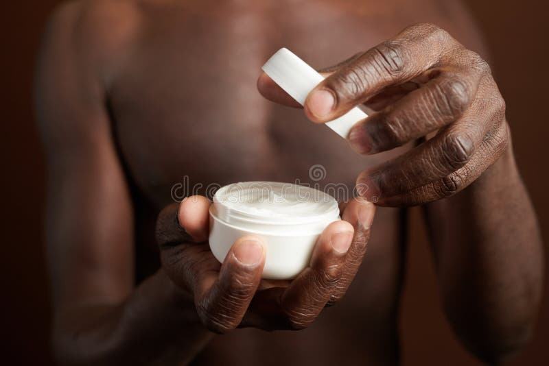 Hombre sin camisa abriendo la crema para el procedimiento fotos de archivo libres de regalías