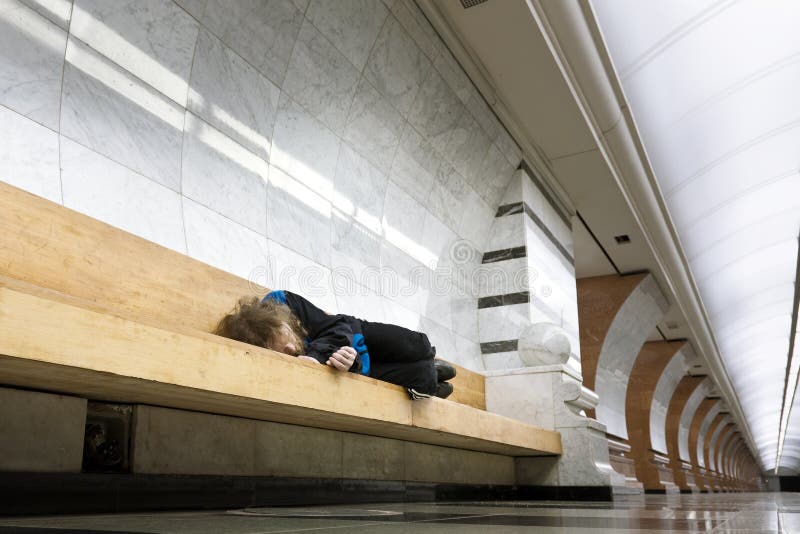 Hombre sin hogar que duerme en el banco imagen de archivo Hombre sin hogar que duerme en el banco imagen de archivo
