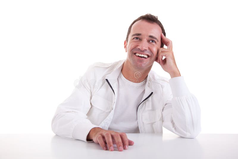 Hombre sonriente de la medio-edad que se sienta en el escritorio fotos de archivo Hombre sonriente de la medio-edad que se sienta en el escritorio fotos de archivo