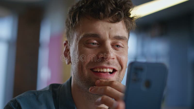 Hombre sonriente mirando el smartphone en el armario de la oficina. empresario risible metrajes