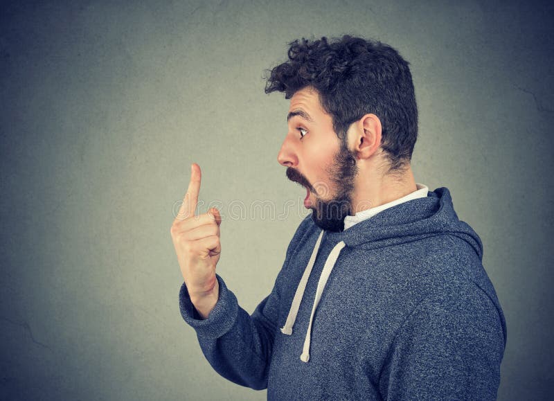 Hombre sorprendente que mira el finger en choque foto de archivo Hombre sorprendente que mira el finger en choque foto de archivo