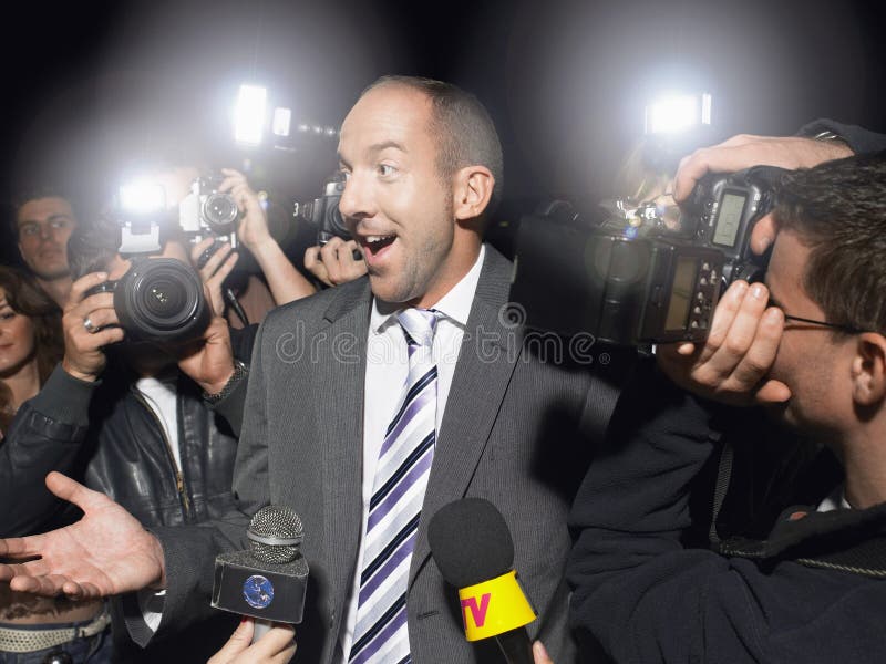 Hombre sorprendido rodeado por los paparazzis imagenes de archivo Hombre sorprendido rodeado por los paparazzis imagenes de archivo