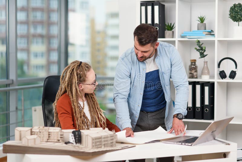 Hombre trabajador highskilled creativo y diseñadores de mujeres que trabajan con la maqueta de los futuros edificios imagen de archivo