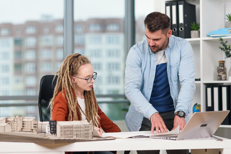 Hombre trabajador highskilled creativo y diseñadores de mujeres que trabajan con la maqueta de los futuros edificios fotos de archivo