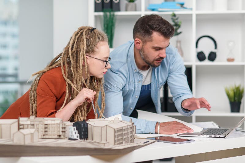 Hombre trabajador highskilled creativo y diseñadores de mujeres que trabajan con la maqueta de los futuros edificios fotos de archivo libres de regalías