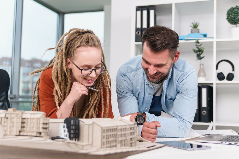 Hombre trabajador highskilled creativo y diseñadores de mujeres que trabajan con la maqueta de los futuros edificios imagen de archivo libre de regalías
