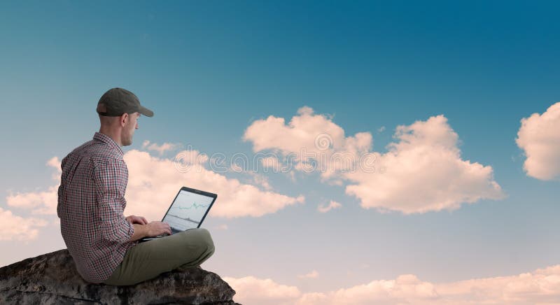 Hombre trabajando a distancia al aire libre con portátil fotos de archivo