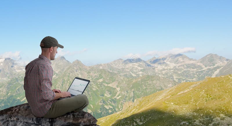 Hombre trabajando a distancia al aire libre con portátil foto de archivo