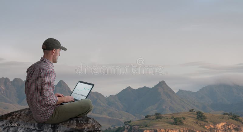 Hombre trabajando a distancia al aire libre con portátil fotografía de archivo