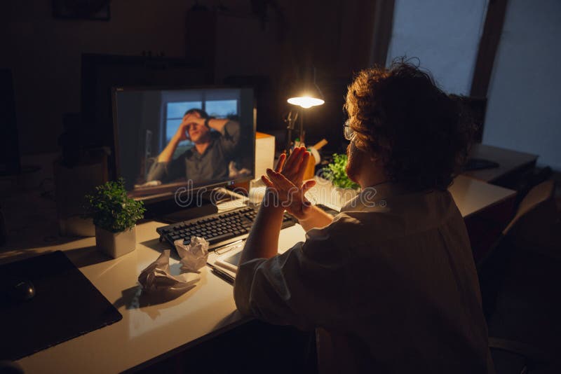 Hombre trabajando solo en el cargo durante la cuarentena del coronavirus o del COVID-19, permaneciendo hasta tarde en la noche fotografía de archivo libre de regalías Hombre trabajando solo en el cargo durante la cuarentena del coronavirus o del COVID-19, permaneciendo hasta tarde en la noche fotografía de archivo libre de regalías